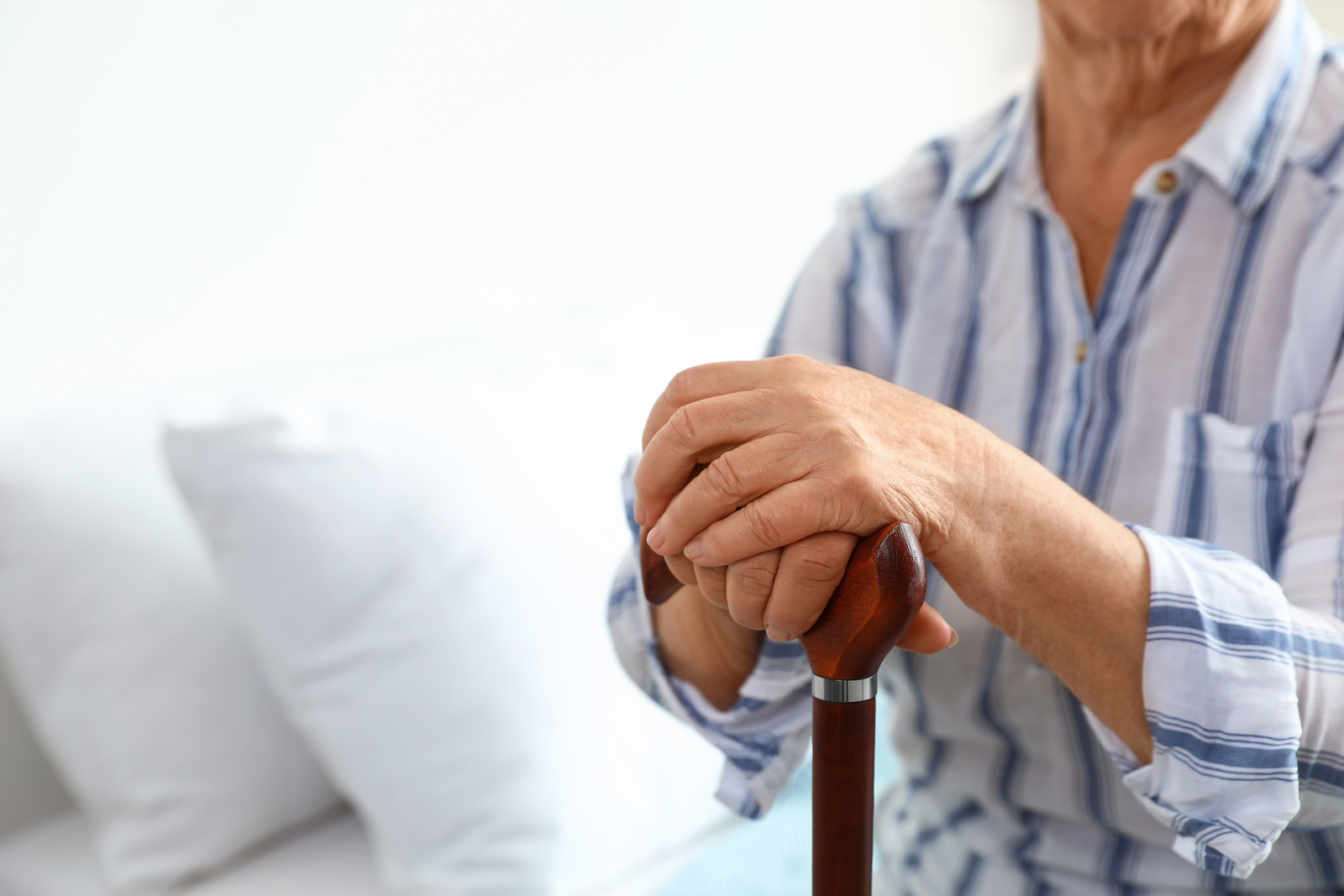 photo of an elderly woman with walking cane in nursing home