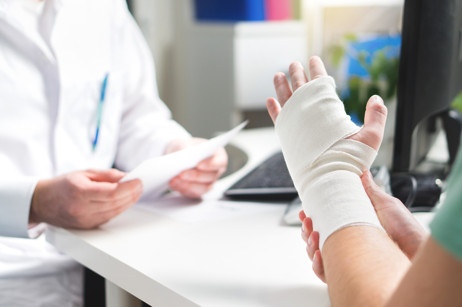 Injured Patient Showing Doctor Broken Wrist And Arm With Bandage
